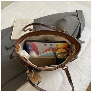 Détail d'un grand sac cabas en cuir marron montrant l'espace de rangement interne