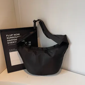 Modern black nylon crescent crossbody bag with adjustable strap and dual zipper closure