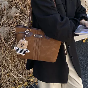 Grand sac cabas en suédine marron pour femme avec charm ours, porté par un mannequin