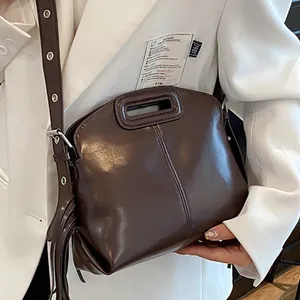 Borsa a tracolla in pelle lucida testa di moro con manico ritagliato e nappa decorativa