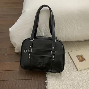Gros plan du sac en cuir noir brillant avec rivets en cœur et poignées polies
