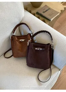 Detail of vintage suede bucket bags in tan and dark brown with metal twist-lock buckle