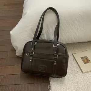 Détails macro d'un sac en similicuir marron brillant avec rivets en forme de cœur