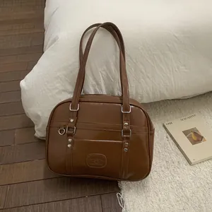 Gros plan d'un sac en simili cuir marron avec boucles cœur sur un tapis doux