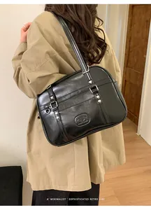 Détail du sac bandoulière noir en similicuir avec boucles et rivets en forme de cœur rétro