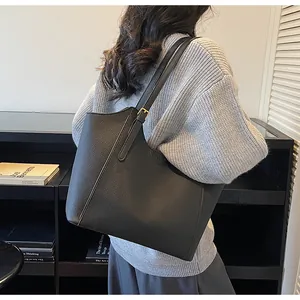 Close-up of black lychee grain leather texture on a spacious commuter tote bag