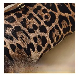 Makroaufnahme von Kunstleder mit Leopardenmuster und goldenen Metallschnallendetails