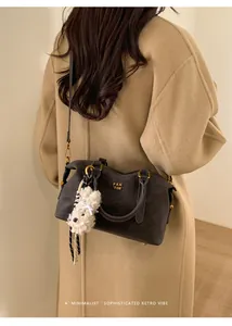 Minimalist retro dark grey crossbody bag with gold hardware and plush puppy charm detail
