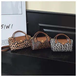 Detail von drei Mini-Handtaschen mit Leopardenmuster, Lederklappen und Goldbeschlägen