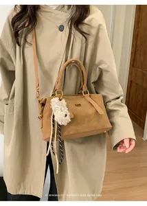 Brown retro shoulder bag with golden logo and cute white puppy charm accessory