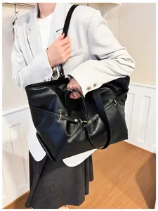 Primo piano della borsa tote in ecopelle nera con anello metallico e dettagli di rivetti