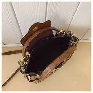 Detailansicht der Leopard-Handtasche mit goldenen Beschlägen und schwarzem Innenfutter
