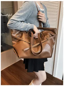 Dettaglio della grande borsa tote marrone con fibbie in metallo e trama in morbida pelle