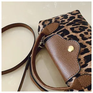 Detail der Crossbody-Tasche mit Leopardenmuster, braunem Leder und goldener Schnalle