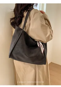 Detail of matte leather tote bag with vintage scarf handle and slim shoulder straps