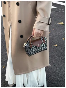Detail der Handtasche mit Leopardenmuster, Lederbesatz und goldenen Beschlägen zum Trenchcoat