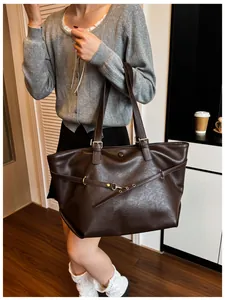Dettaglio della borsa tote vintage in pelle marrone scuro con trama martellata e fibbia