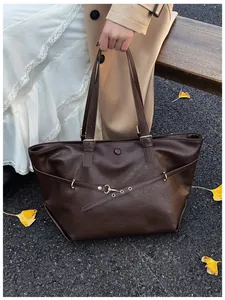 Dettaglio della borsa tote marrone vintage con trama in pelle e fibbia dorata in autunno