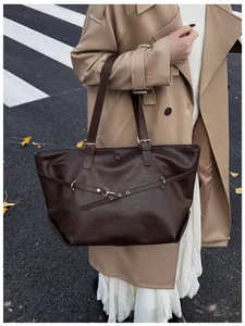 Dettaglio della borsa tote vintage marrone con fibbia dorata e texture in pelle