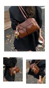 Dettaglio della borsa a spalla vintage marrone scuro con doppie tasche e ciondolo a orsetto