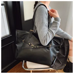Dettaglio della borsa tote vintage in pelle PU nera con accessori dorati e tracolla