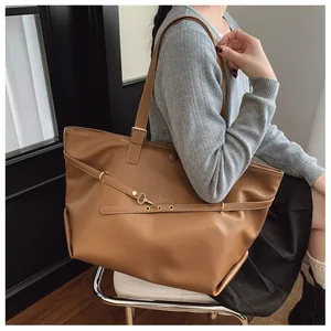 Dettaglio ravvicinato della borsa tote vintage marrone con fibbie metalliche e borchie