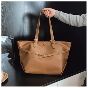 Dettaglio borsa tote in pelle PU marrone con spallacci regolabili e gancio decorativo