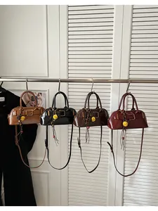 Close-up of retro shell bags in four colors with decorative buckles and floral charms