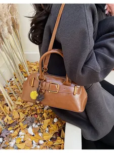 Detailed view of a brown vintage shell bag with gold hardware and a decorative pompom charm