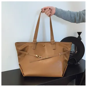 Dettaglio della borsa tote in pelle PU marrone scuro con fibbia dorata e cinturino regolabile