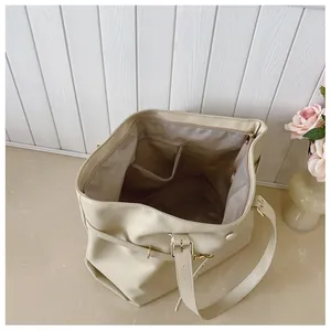 Vista interna della borsa tote crema che mostra l'ampio scomparto e la tasca con zip