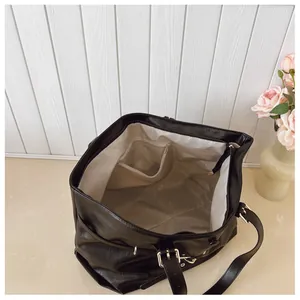 Vista interna della borsa tote nera con fodera beige, tasca con cerniera e scomparto aperto