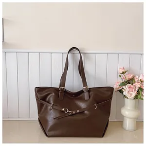 Dettaglio borsa tote in ecopelle marrone scuro con fibbia in metallo e texture vintage