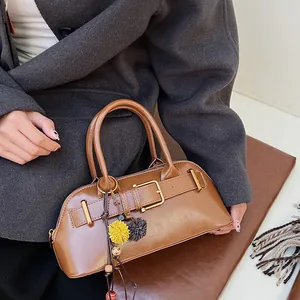 Vintage brown shell-shaped handbag with gold buckle and fuzzy charm for daily commute