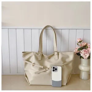 Dettaglio borsa tote color crema con fibbie dorate e ampio spazio interno capiente