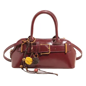 Retro burgundy shell handbag with decorative belt buckle and ethnic style tassel charm