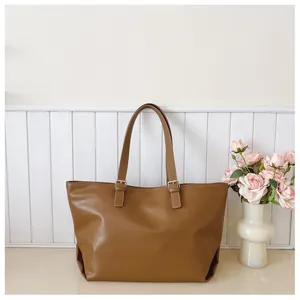 Dettaglio della borsa tote vintage marrone caramello con trama in pelle e fibbia metallica
