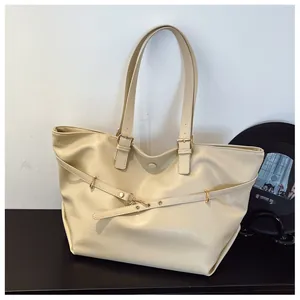 Dettaglio della borsa tote color crema con trama in pelle testurizzata e fibbie regolabili
