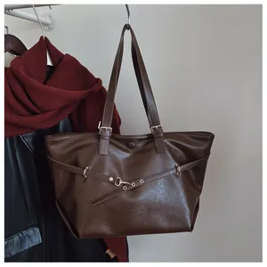Dettaglio della borsa tote vintage marrone scuro con trama lucida e fibbia in metallo