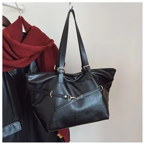 Dettaglio borsa shopper nera in ecopelle con fibbie in metallo dorato eleganti