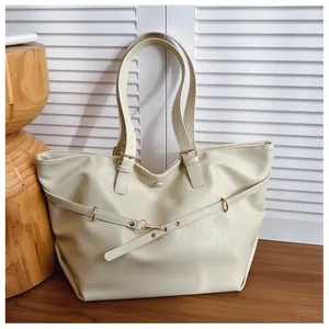 Dettaglio della borsa tote in pelle bianco crema con texture e fibbia dorata