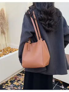 Detail of brown leather tote bag with contrast white stitching and geometric design