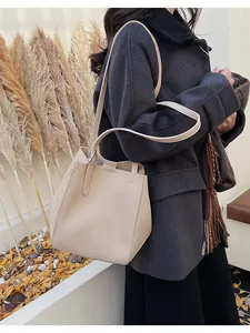 Detail of beige bucket bag with lychee texture leather and a stylish geometric structure