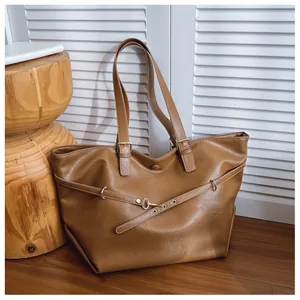 Dettaglio della borsa tote marrone in pelle sintetica con fibbie in metallo e stile retrò