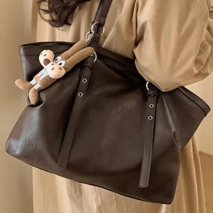 Retro large leather tote bag in dark brown with plush bunny charm shown on model