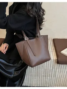 Detail of brown lychee grain leather tote bag featuring white contrast stitching and hardware