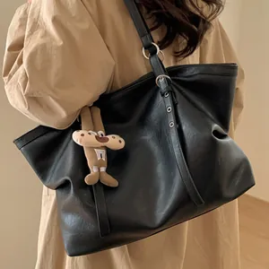 Large black vintage tote bag in soft leather with a plush charm and silver hardware