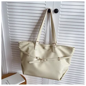 Dettaglio borsa tote color crema con tracolle regolabili e decorazioni con occhielli