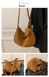 Detail view of brown faux suede crescent bag with matching pouch and golden logo