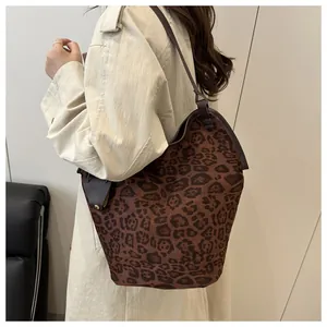 Leopard print tote bag with brown leather trim styled on model in beige trench coat